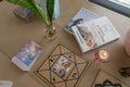 First Light Chakra & Aura Check: Bruna reading with the pendulum over a board with crystals, her cat beside her