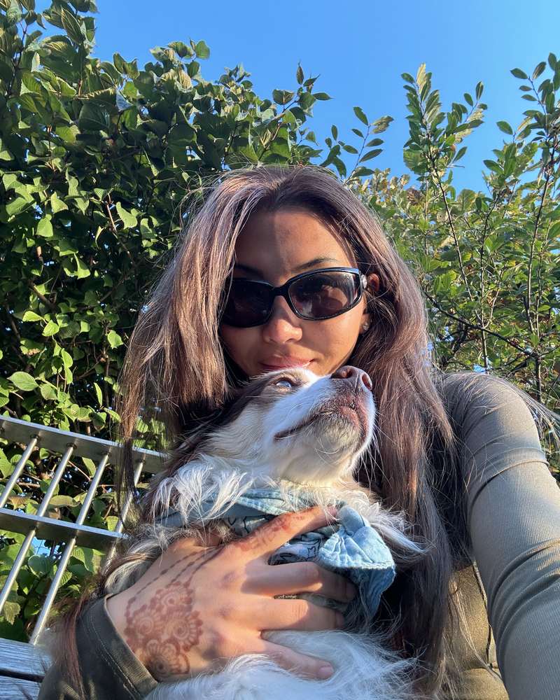 Eileen holding Obi, her Australian shepherd, in the garden